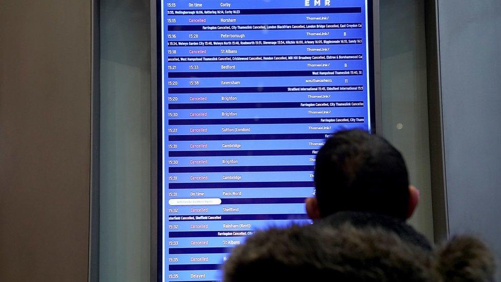 A view of a commuter looking at an information board at St Pancras International station, London