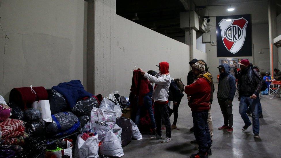 Homeless people look through bags of donated clothes at River Plate stadium in Buenos Aires, Argentina on 3 July 2019