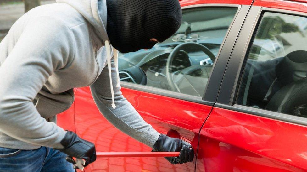 Burglar breaking into car