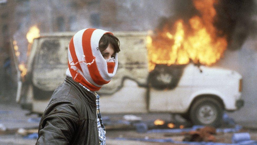 Protestor in front of burning car