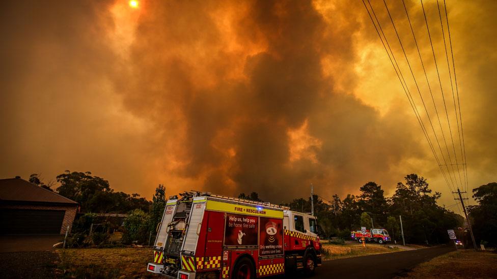 Firemen prepare as a bushfire approaches homes on the outskirts of the town of Bargo on December 21, 2019 in Sydney, Australia.