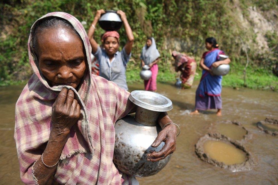 Indian tribal women collect water from small stream for drinking on 3 April 2018 near Agartala in India.