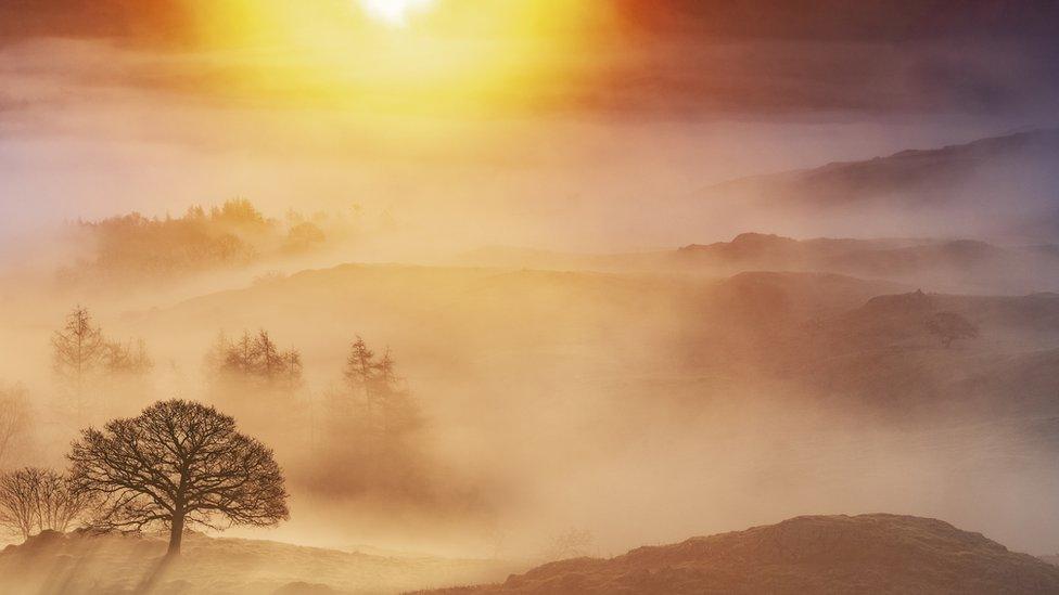 Sunrise over foggy Lake District valley