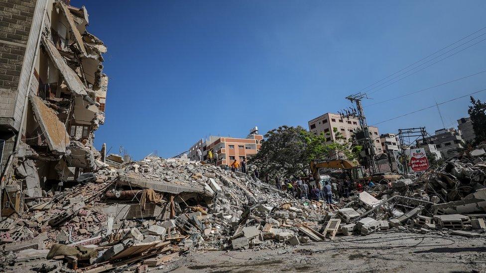 Palestinian civil defence workers search for people trapped under the rubble of destroyed buildings in Gaza City (16 May 2021)