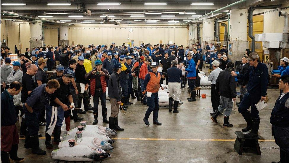 Buyers, workers and auctioneers attend the final tuna auction at the landmark Tsukiji fish market in Tokyo on October 6, 2018