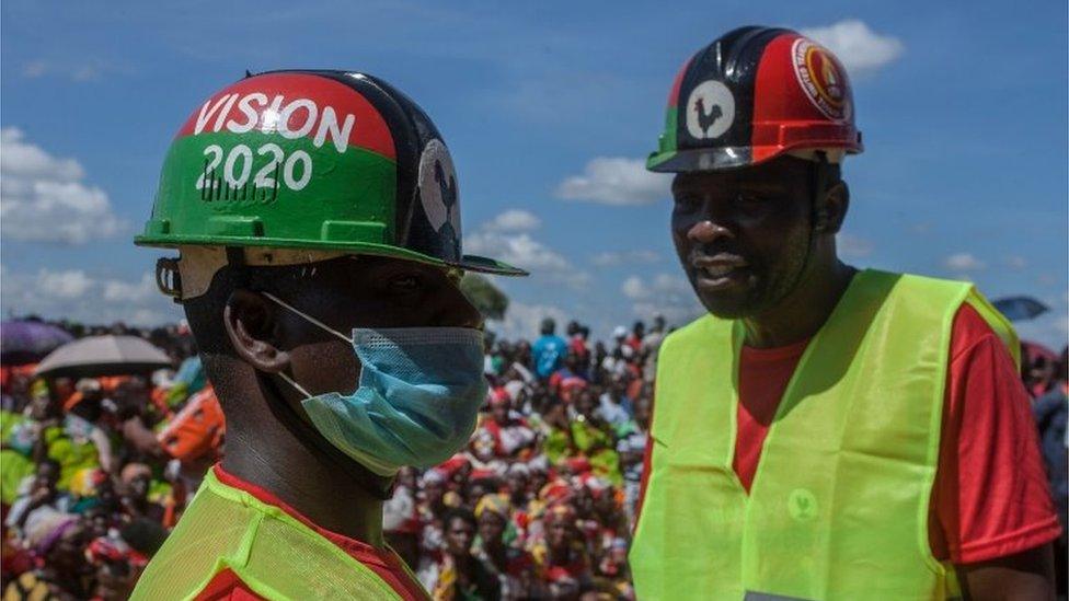 A political supporter wears a face mask and gloves as a preventive measure against the COVID-19 coronavirus while attending an event of a signed an electoral alliance of the Malawi Congress Party (MCP) and United Transformation Movement (UTM) in Lilongwe on March 19,