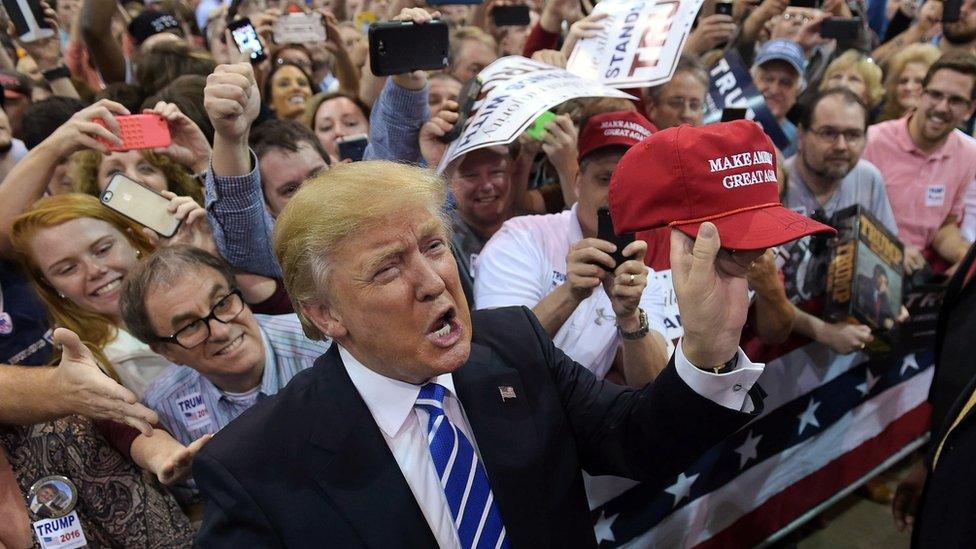 Republican presidential candidate Donald Trump holds up a cap that he signed for a supporter during a rally at the Expo Hall of the Richmond International Raceway on October 14, 2015 in Richmond, Virginia.