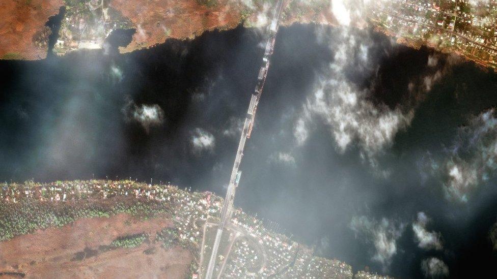 A high-resolution satellite image shows damage to multiple sections of the Antonivsky Bridge