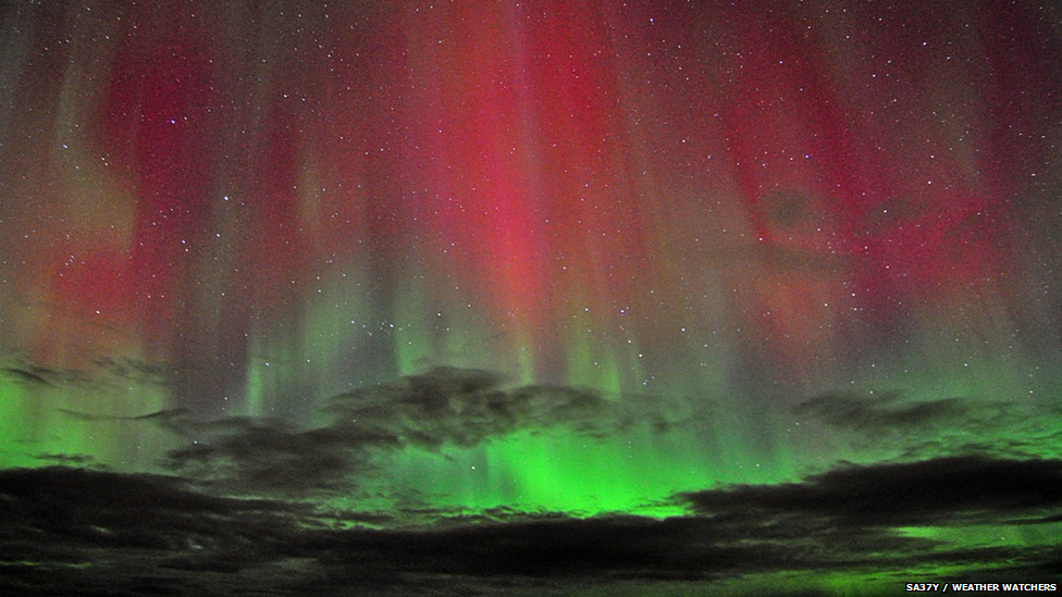 Aurora made up of reds and greens filling the whole night sky.