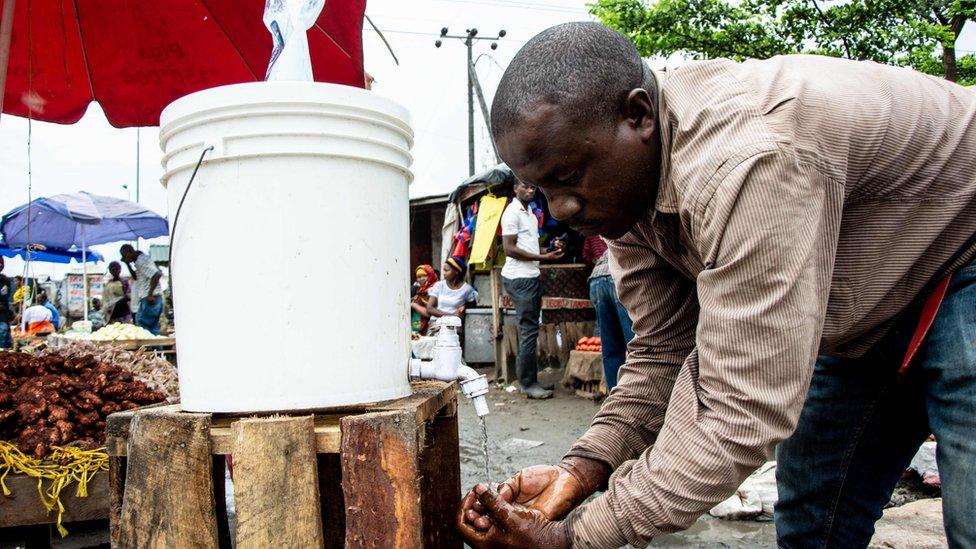 A man washes his hands with chlorinated water at the Mabibo market in Dar es Salaam, Tanzania, on April 16, 2020