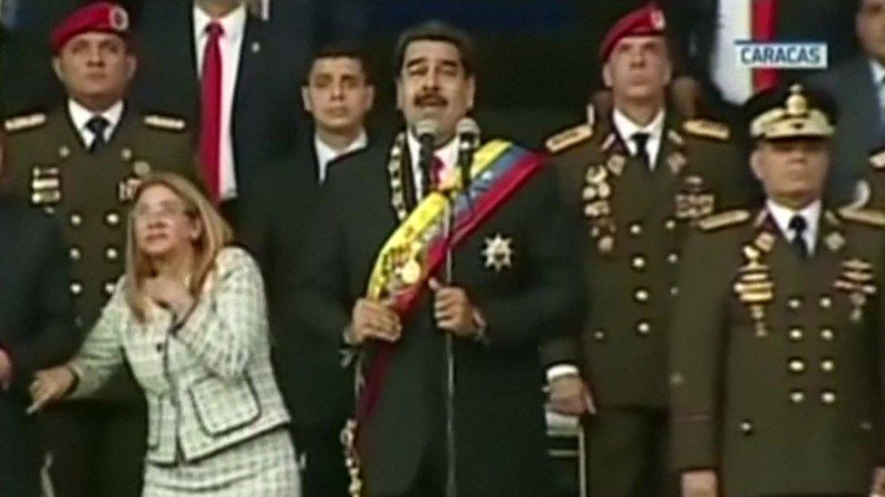 President Maduro (centre) and his wife Cilia Flores (left) react to a loud bang during the military event