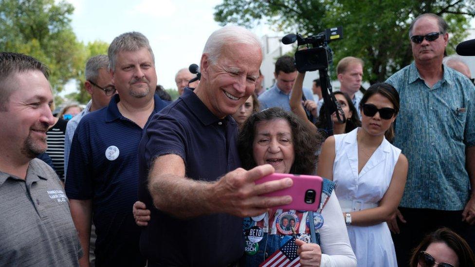 Joe Biden takes a photo with a woman in Iowa