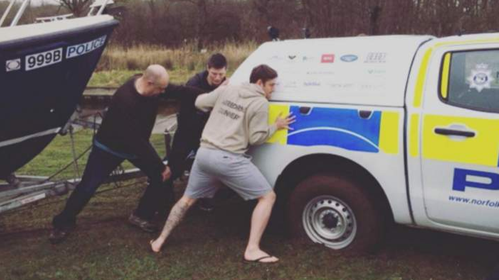 Man pushing stuck police boat