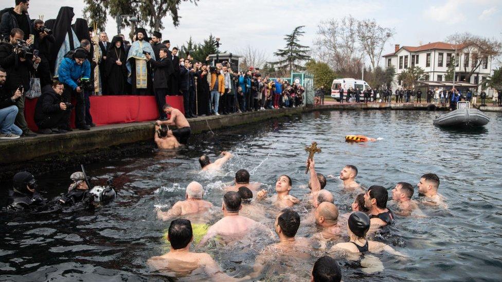 Greek Orthodox Christian held up a wooden cross after retrieving it from the waters of the Golden Horn in Istanbul, Turkey.