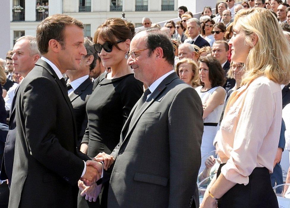 French President Emmanuel Macron shaking hands with predecessor Francois Hollande