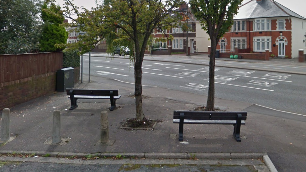 Two benches overlooking a busy road in Cardiff.