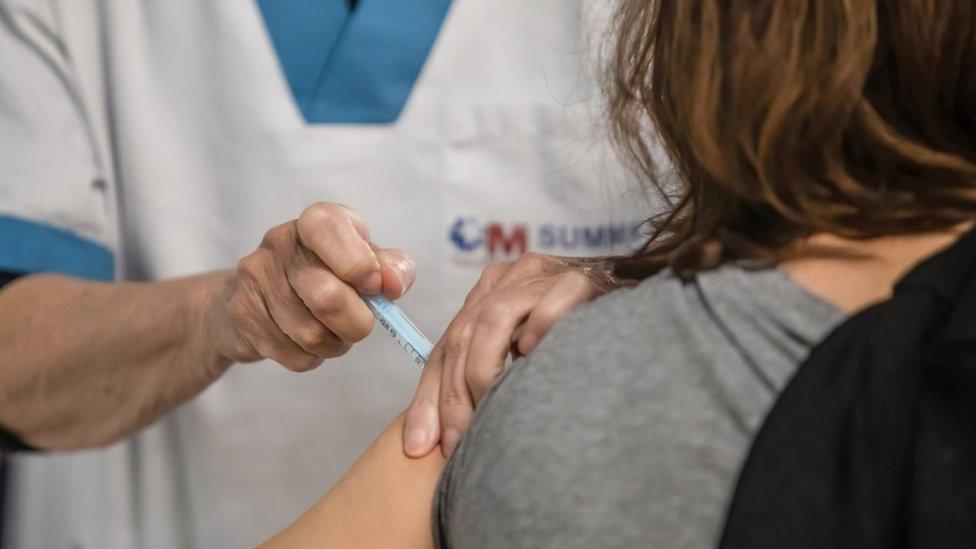 A woman receives an AstraZeneca shot in Madrid