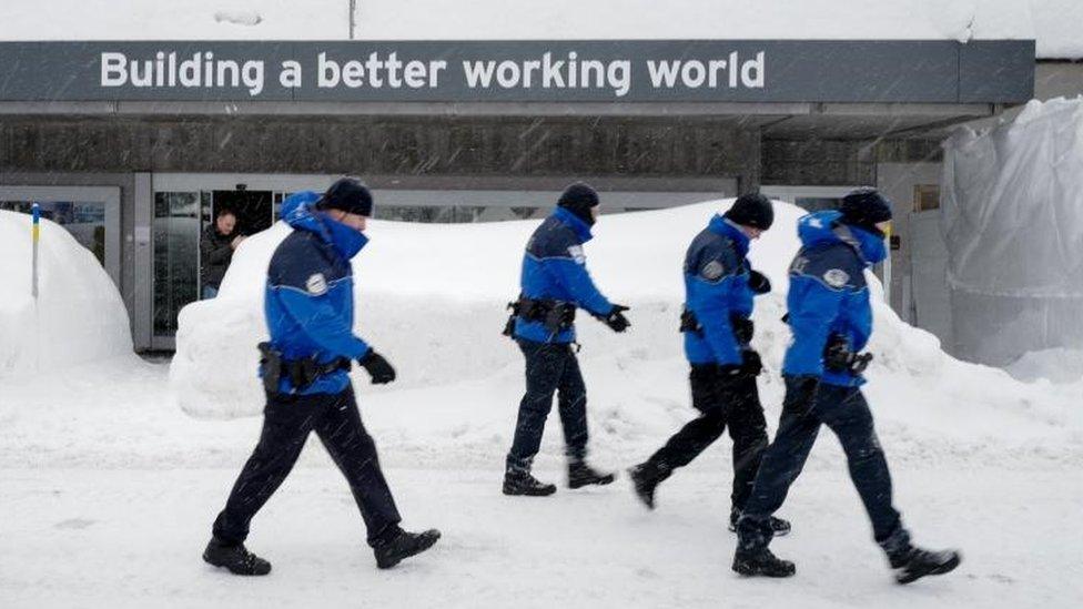 Policemen walk across show ahead of the opening of the World Economic Forum 2018 annual meeting