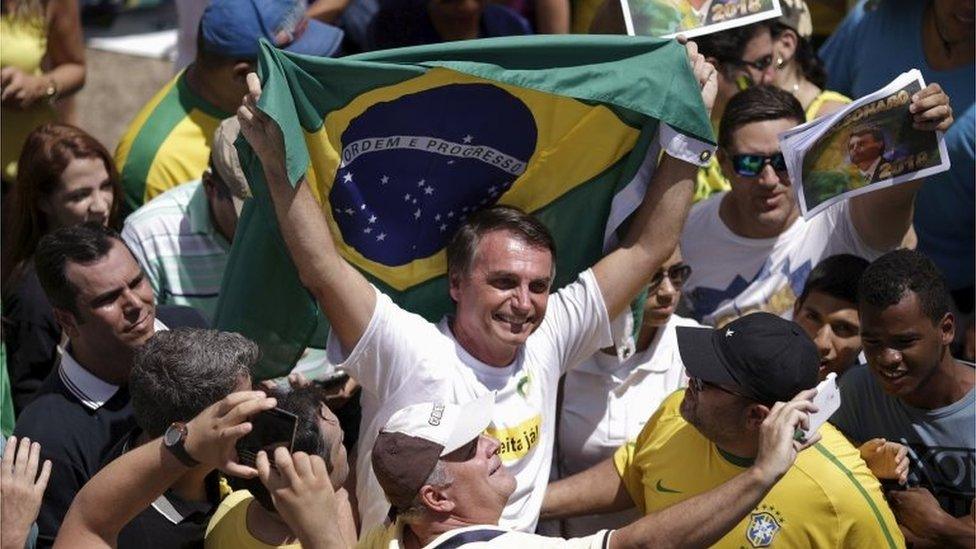 Congressman Jair Bolsonaro holds a Brazilian flag during a protest against Brazil's President Dilma Rousseff, part of nationwide protests calling for her impeachment, in Brasilia, Brazil, March 13, 2016