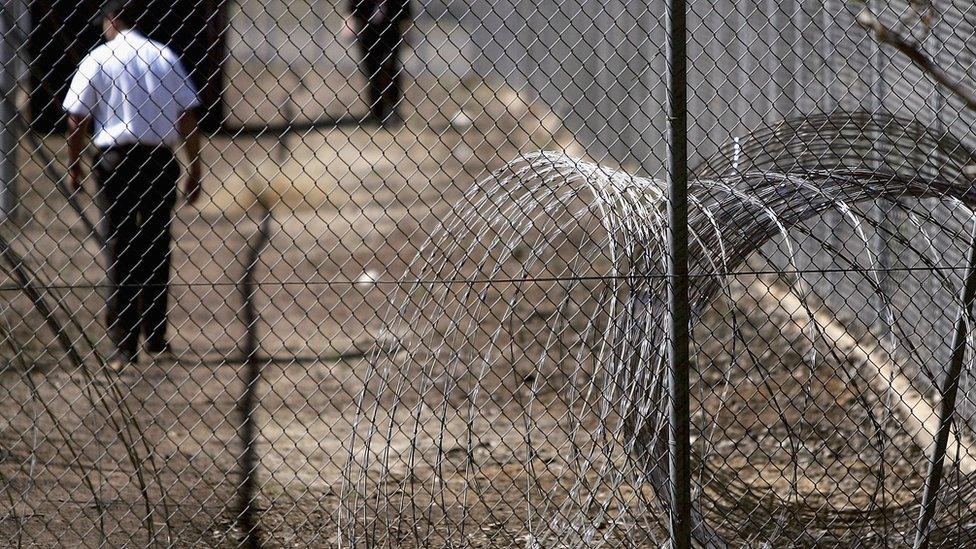 Razorwire and a prison guard