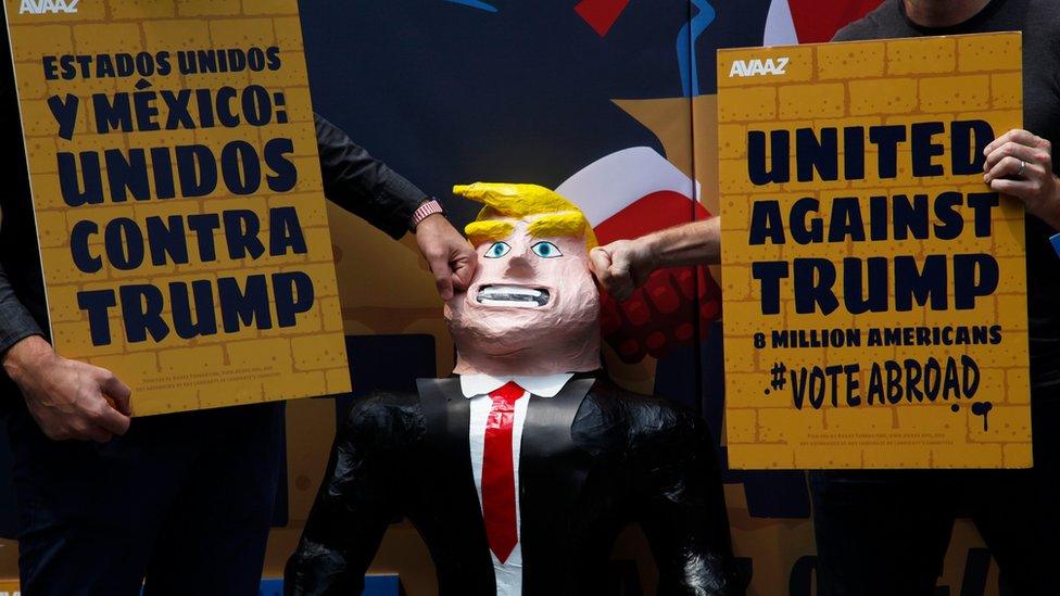 A couple of men hit a pinata representing U.S. Republican presidential candidate Donald Trump leaning against a symbolic wall, at the Independence Angel monument in Mexico City, Sunday, Sept. 25, 2016