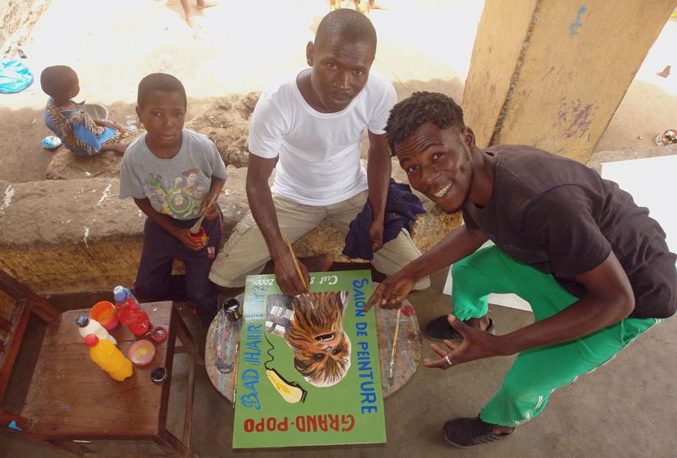 Houenoude painting and surrounded by his two children and friend Gustavo