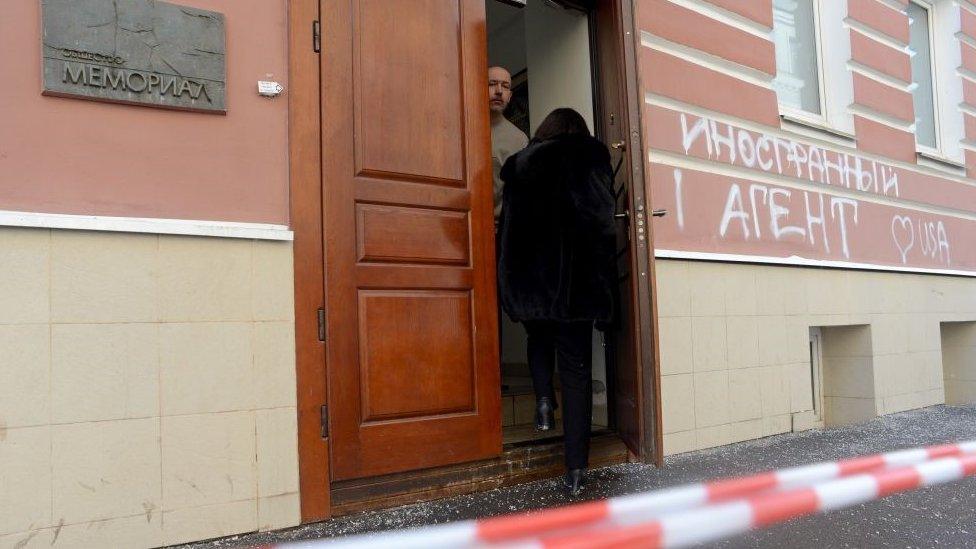 People stand at one of the entrances to the Memorial rights group office in Moscow, on March 21, 2013