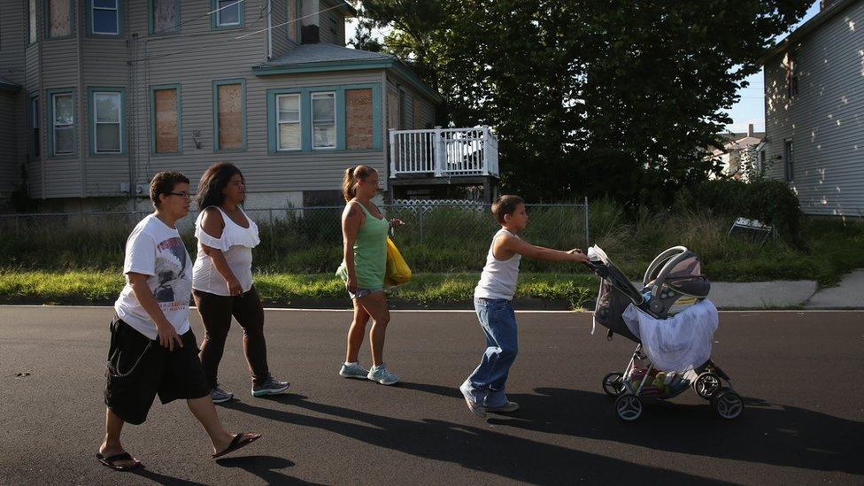 A group walks past a boarded-up house in Atlantic City