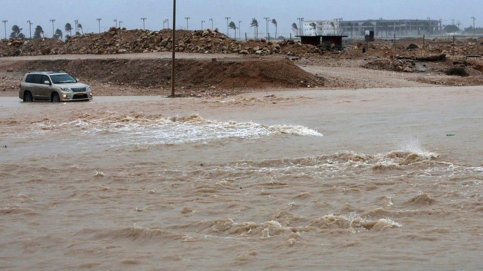 A car driving through a flooded street in the southern city of Salalah, Oman, 25 May 2018