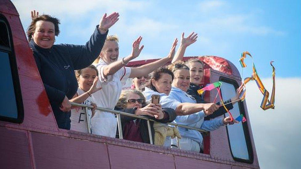 Key workers waving from an open-top bus