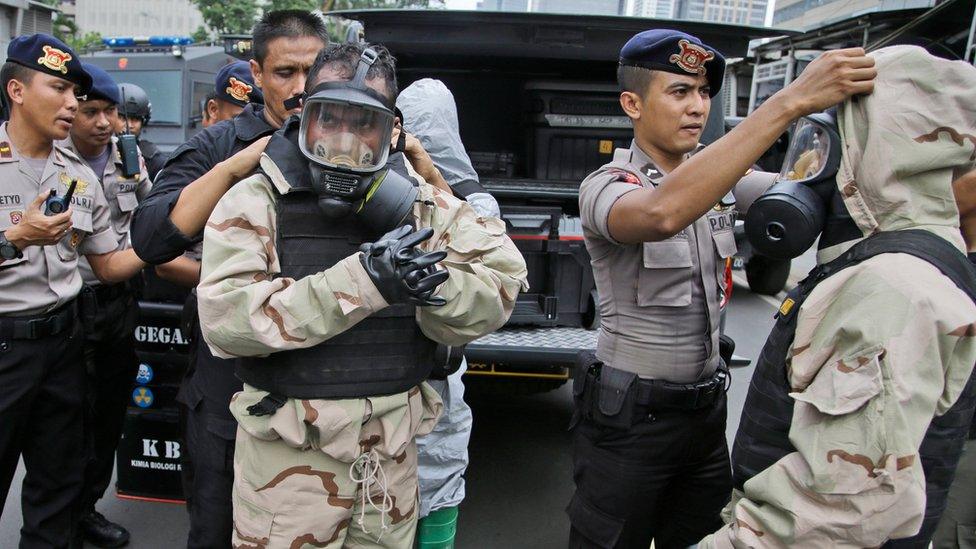 Members of the police bomb squad put on their protective gear prior to examining the site where an explosion went off in Jakarta, Indonesia Thursday, Jan. 14, 2016