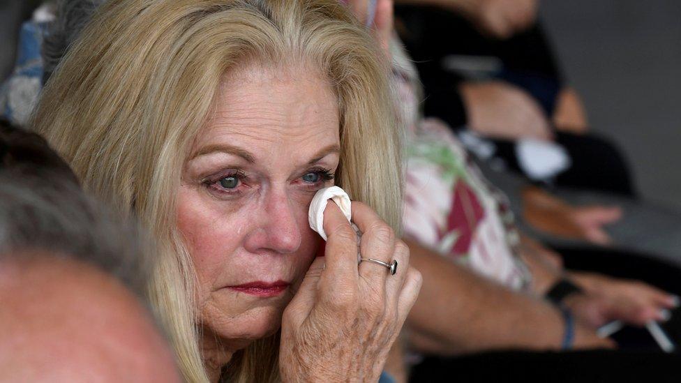 A woman cries as caskets are handed over in Honolulu, Hawaii