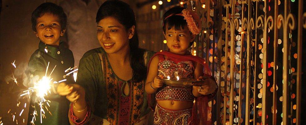 A family enjoy sparklers on the eve of Hindu festival Diwali in 2014