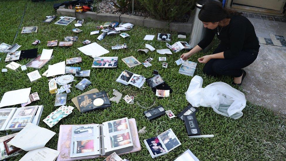 Stephanie Martinez tries to dry family pictures after flood water inundated her home on September 1, 2017 in Houston, Texas