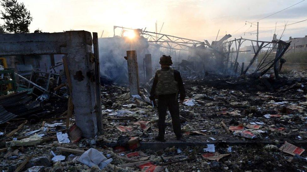 A police expert looks at damages on an industrial area in the Ukrainian capital of Kyiv after a missile attack on 21 September