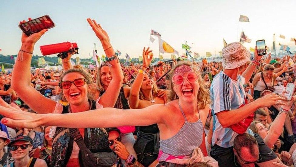 Crowds cheering and dancing at a festival