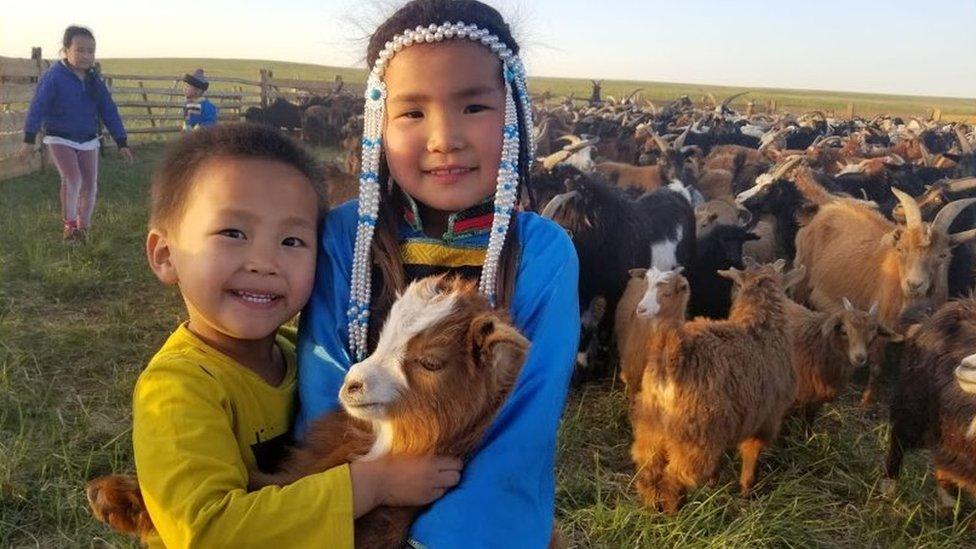 Two Mongolian children with a goat