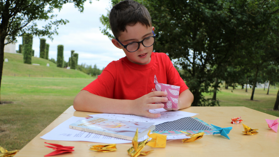 Boy folding origami crane