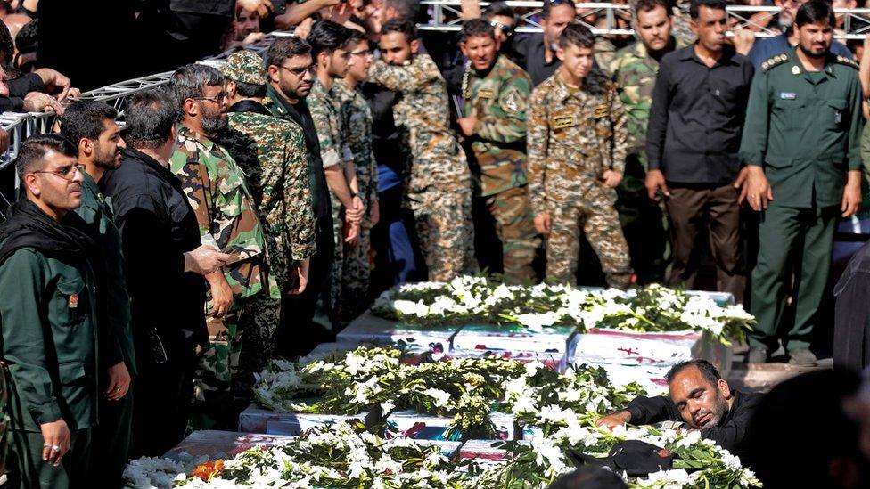 Iranian military personnel mourn over the bodies of people killed in the attack on a military parade in Ahvaz (24 September 2018)