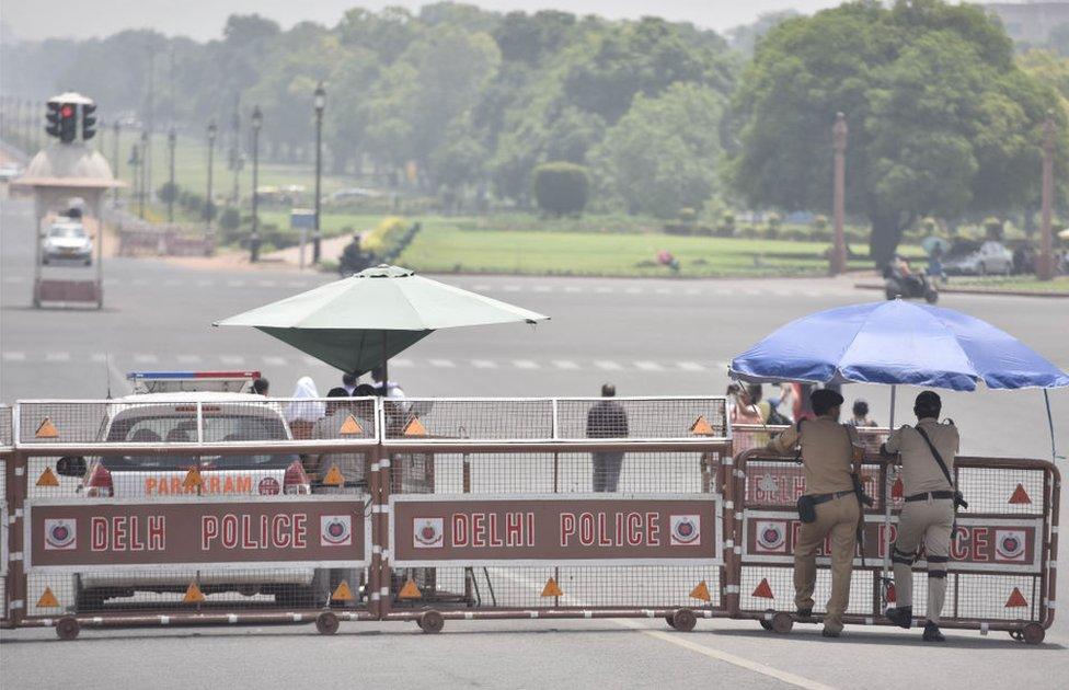 Policemen stand guard under an umbrella on a hot afternoon at Raisina Hills as temperature rises above 45 degree celsius, on June 1, 2019 in New Delhi, India.