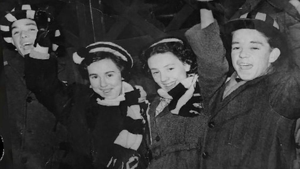 Two girls and two boys in Newcastle United scarves and hats