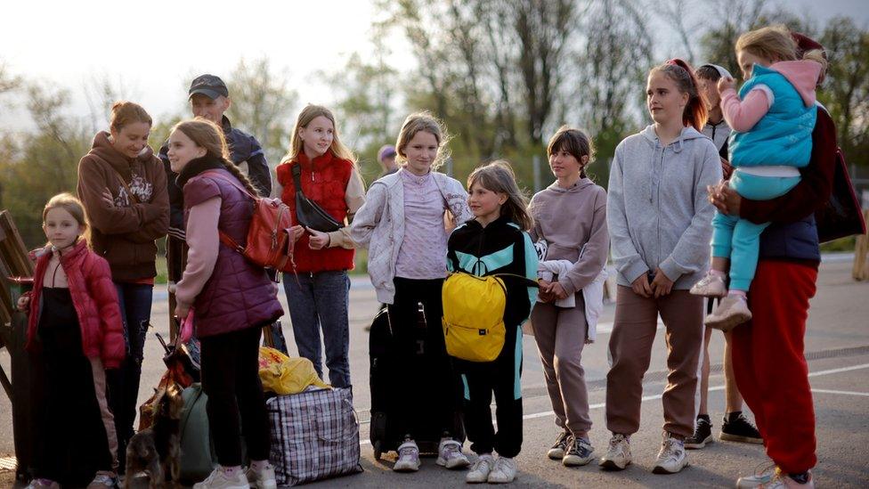 A refugee Ukrainian family stand after arriving at a registration centre for internally displaced people, amid Russia"s invasion of Ukraine, in Zaporizhzhia,