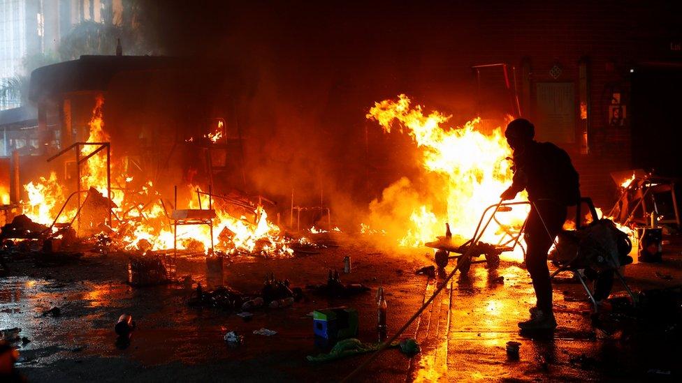 A protester attempts to extinguish a fire at PolyU