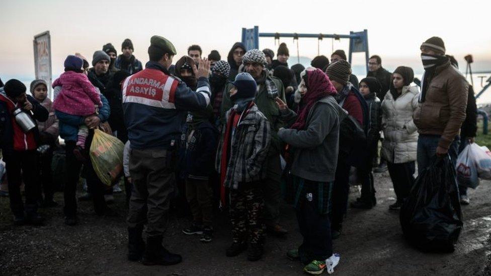 Syrian and Afghan migrants and refugees wait after being caught by Turkish police at Canakkale's Kucukkuyu district. Photo: 27 January 2016