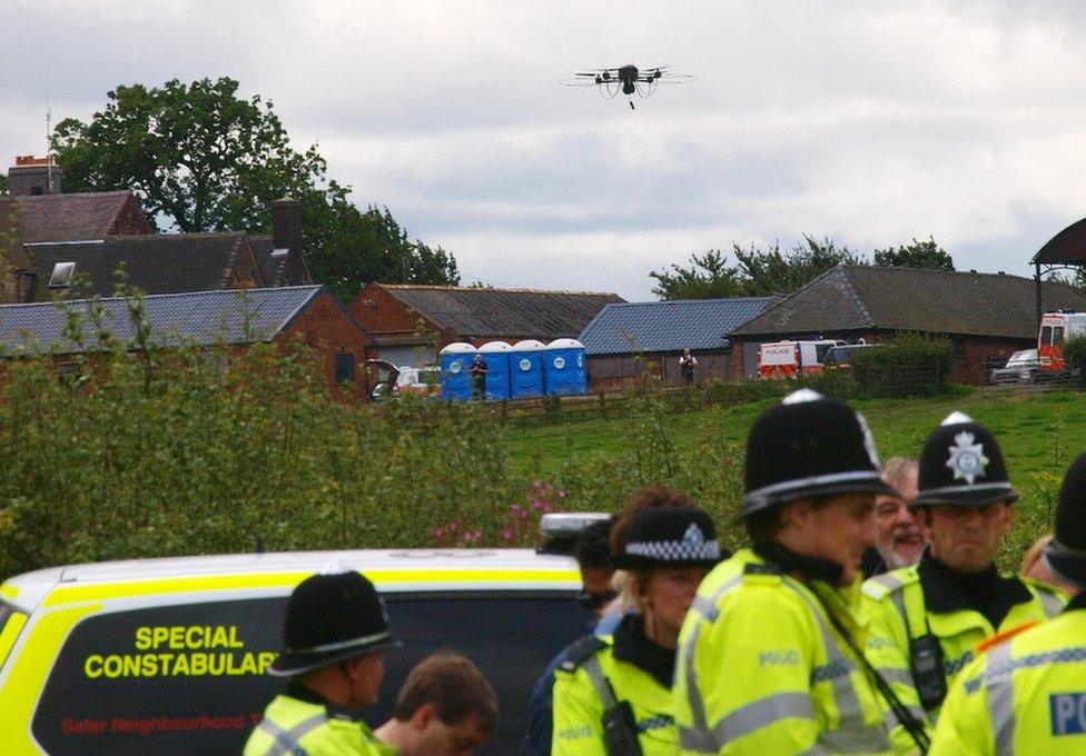 A police drone with cameras flies over a line of police officers blocking anti-BNP protesters near the BNP festival in Codnor on August 15 2009