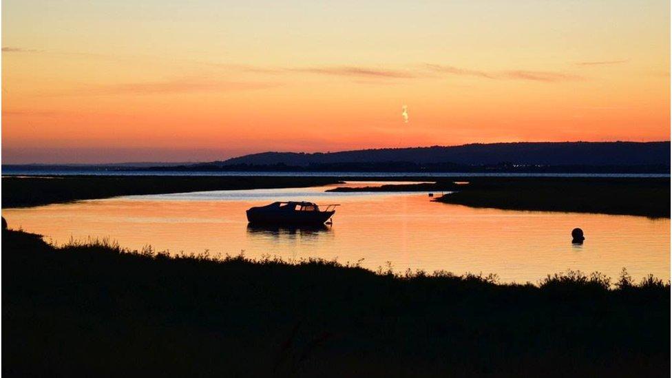 A view of a boat at Penclawdd on Gower at sunset