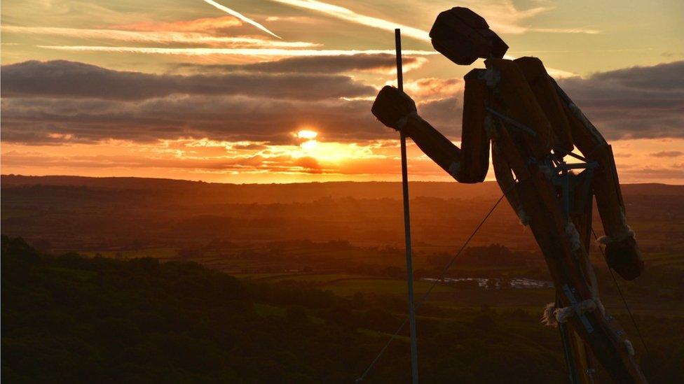 Statue silhouetted at sunset