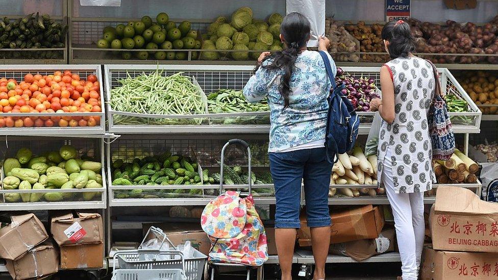 Customers shop for vegetables at a stall in Singapore