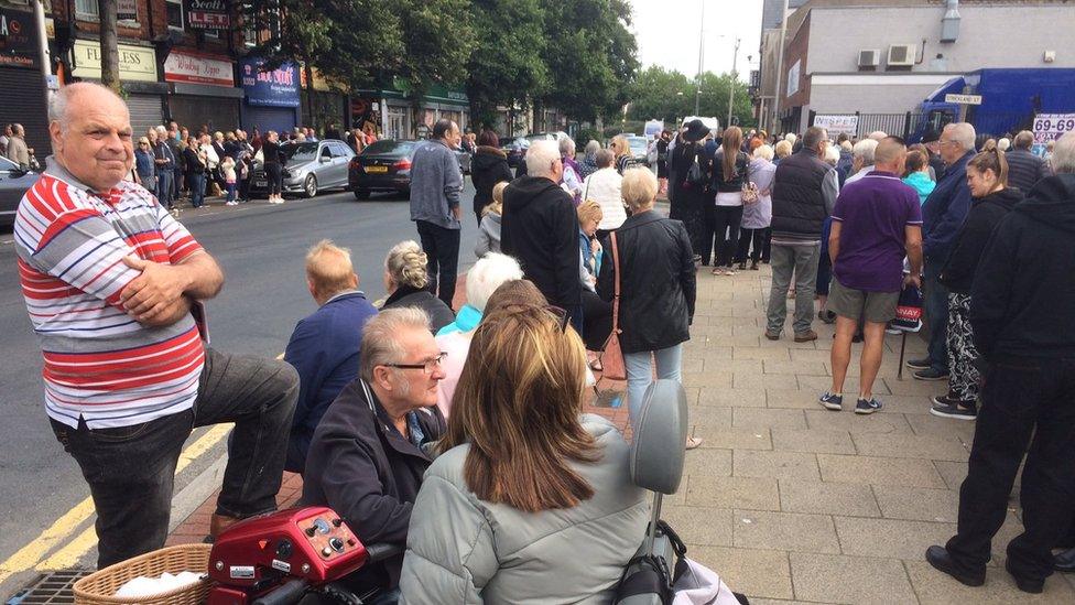 Mourners standing on a main street