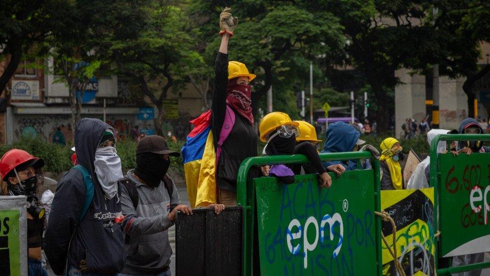 A woman raises her arm at a protest in Medellín on 18 May 2021